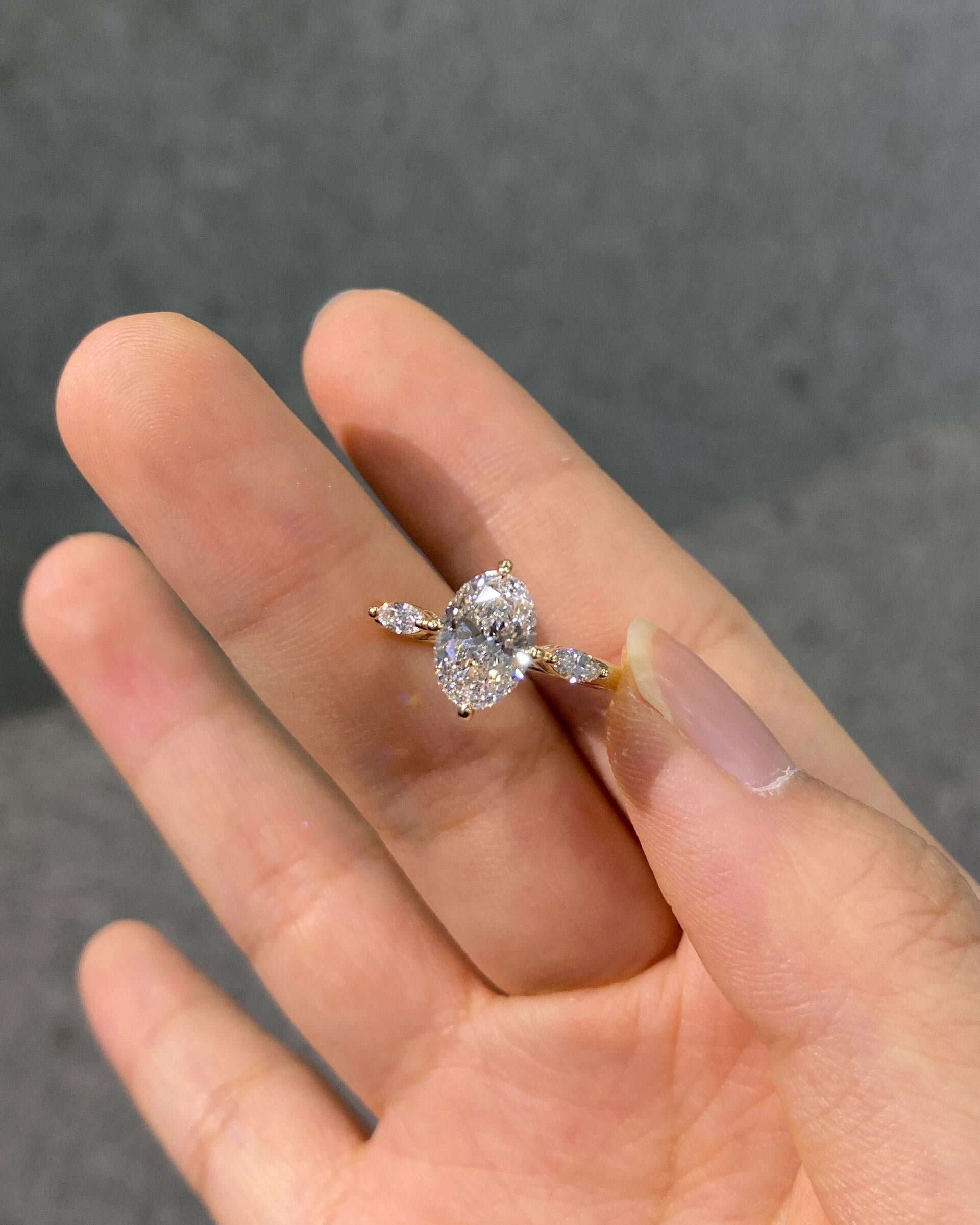 A unique three-stone diamond ring featuring an oval lab-grown diamond—dazzlingly brilliant, Color D, Clarity VS1