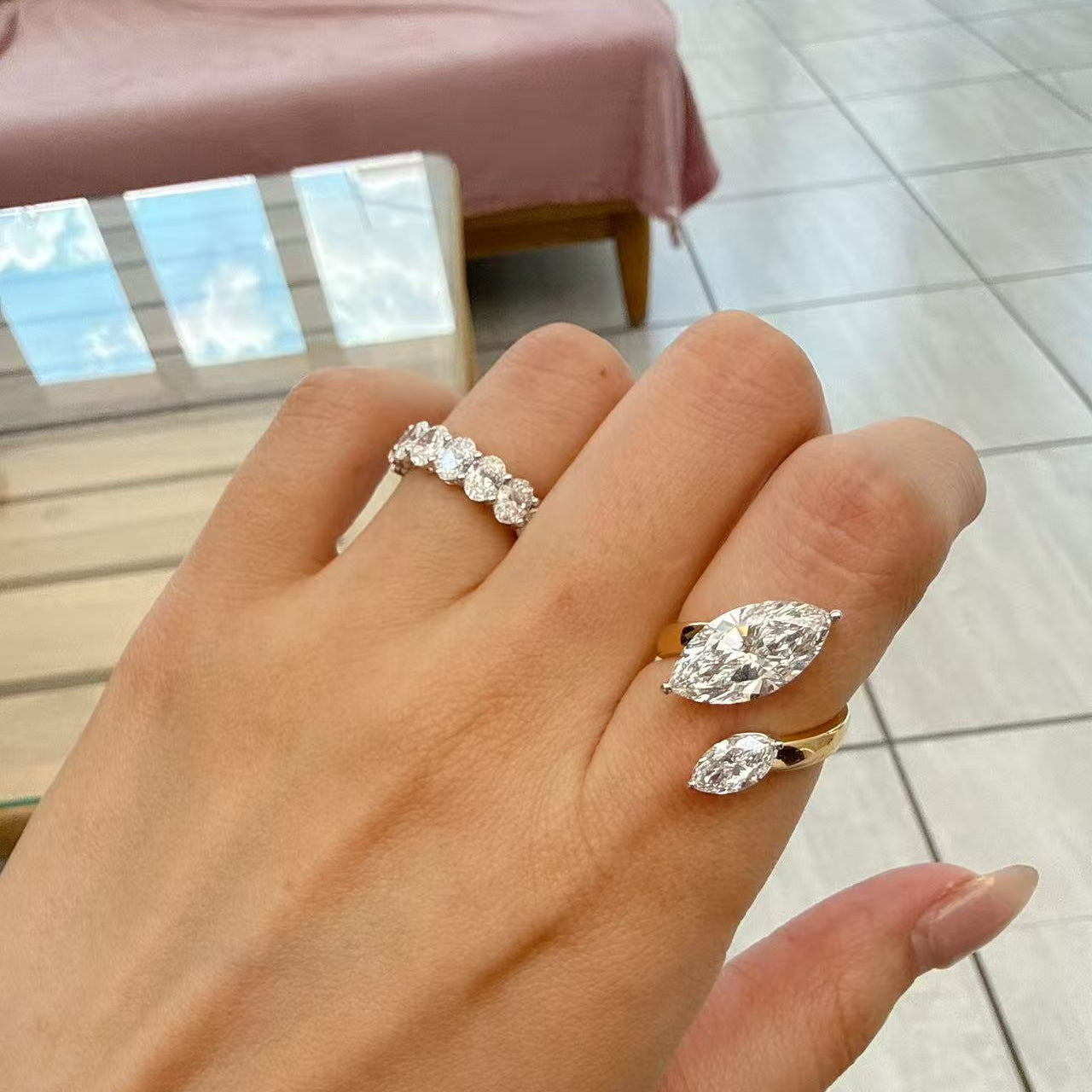 A dual-center-stone ring, set with marquise-cut lab-grown diamonds—radiant with shimmering brilliance and fluid grace, resting elegantly upon the fingertip